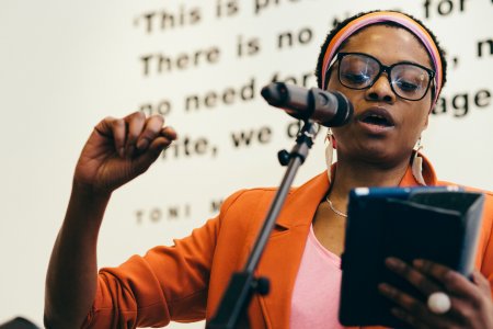 Zena Edwards, poet and performer, reads a text into a microphone.